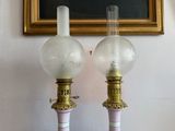two lamps that are sitting on a table in front of a painting