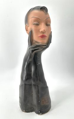 sculpture représentant la tête d'une femme, les mains sur le visage