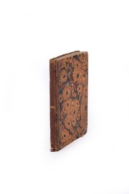 an old book that is sitting on a white surface