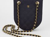 un sac à main noir avec des chaînes dorées et une bandoulière en chaîne