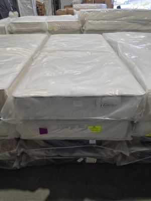many mattresses stacked on top of each other in a warehouse