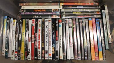 beaucoup de DVD rangés sur une étagère, dans une boîte