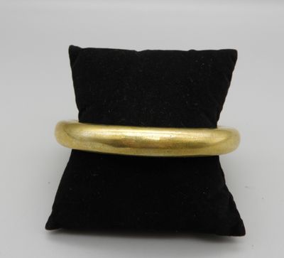 un gros plan d'une bague en or posée sur un coussin noir