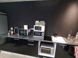 a kitchen with a microwave, oven, sink, and refrigerator