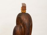 wooden sculpture of an apple on a white pedestal with a white background
