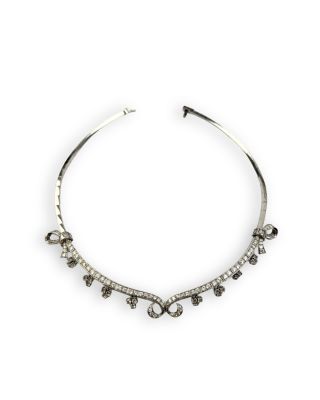 un gros plan d'un collier en argent sur fond blanc