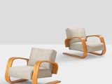 pair of mid - century modern lounge chairs with upholstered backrests