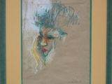 painting of a woman ' s face in a green frame on a wall