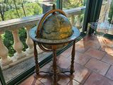 un vieux globe terrestre posé sur une table devant un balcon