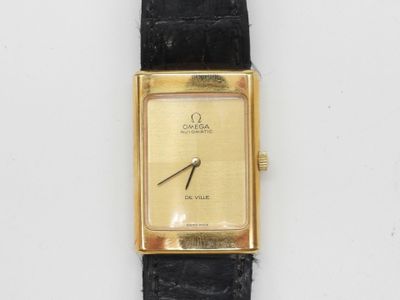 un gros plan d'une montre en or avec un bracelet en cuir noir