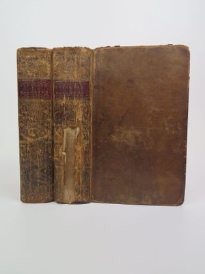 deux vieux livres posés sur une table, sur fond blanc