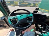 steering wheel of a truck with a man sitting in the driver ' s seat