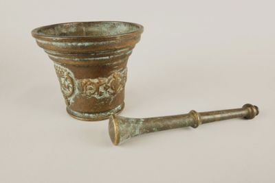 a small metal cup and a wooden handle on a white surface