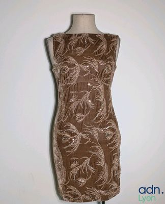 a dress on a mannequin stand with a white wall in the background