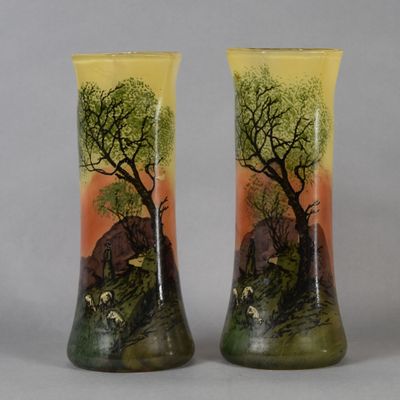 two vases with animals painted on them sitting on a table