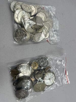 deux sacs d'argent et des pièces d'argent posés sur une table