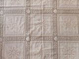 a bed with a white and brown quilt on top of it