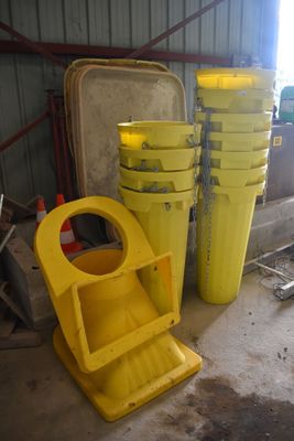Plusieurs seaux jaunes sont empilés les uns sur les autres dans un garage