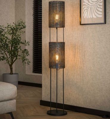 a close up of a lamp on a wooden floor next to a couch