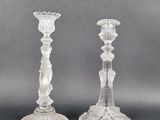 deux bougeoirs en verre transparent posés sur une table