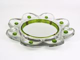 a glass plate with green beads on it on a white surface