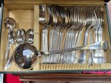 a lot of silver spoons and spoons in a box