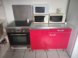 two microwaves on the counter in this small kitchen