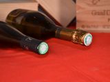 two bottles of wine sitting on a table next to each other