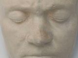 a white sculpture of a man ' s head with his eyes closed