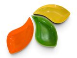 trois plats de couleurs différentes empilés les uns sur les autres sur une surface blanche