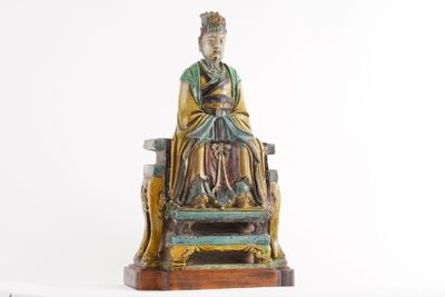 a statue of a man sitting on top of a chair