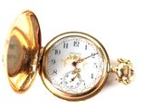 a gold pocket watch sitting on a white surface