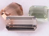 three different colored stones sitting next to each other on a white surface