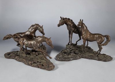 deux sculptures en bronze représentant des chevaux au galop sur un sol rocheux