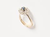 a close up of a gold ring with a blue and white diamond
