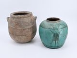 deux vases posés l'un à côté de l'autre sur une surface blanche