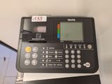 une calculatrice posée sur une table, à côté d'un ordinateur portable
