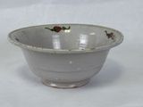 a white bowl with red flowers on it on a white surface