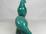 green bird figurine sitting on top of a green base