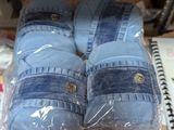 several pairs of blue slippers are wrapped in plastic on a table