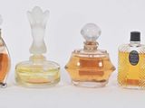 seven different bottles of perfume on a white surface