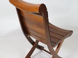 a wooden chair that is sitting on a white surface