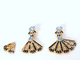 a close up of a pair of earrings on a white surface