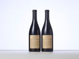 two bottles of wine sitting on top of a table