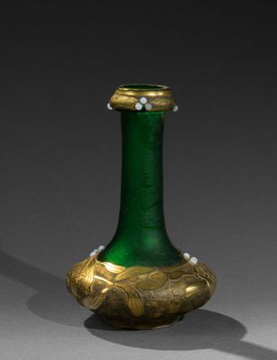 un vase vert et doré orné de perles