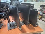 two computer monitors sitting on a desk in a room