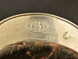 a close up of a silver bowl with a black background