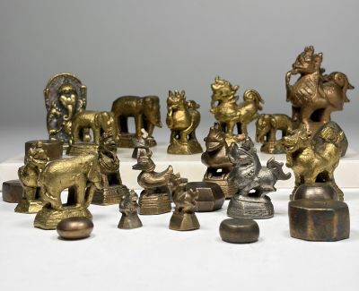 de nombreuses figurines en laiton posées sur une surface blanche