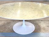 a white table with a marble top on a tile floor