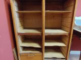 une armoire en bois dans un coin d'une pièce équipée d'un lavabo